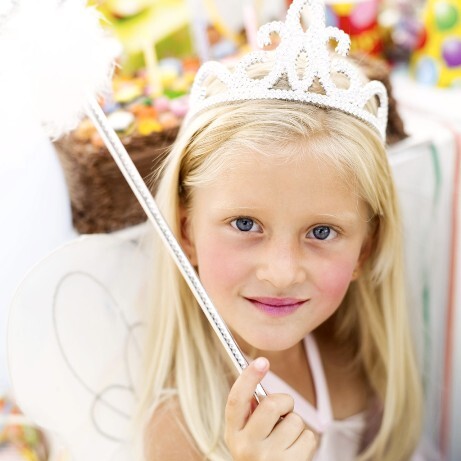 A young girl wearing a tiara and holding a wand, dressed as a princess to represent the imaginative power and social-emotional benefits of reading fiction.