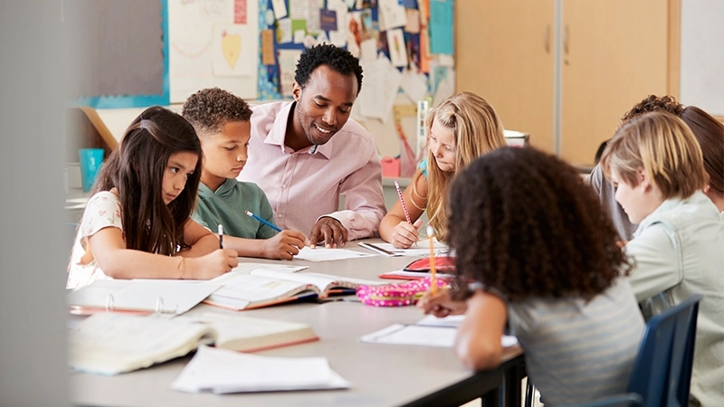 A teacher works in a small group with upper elementary students.